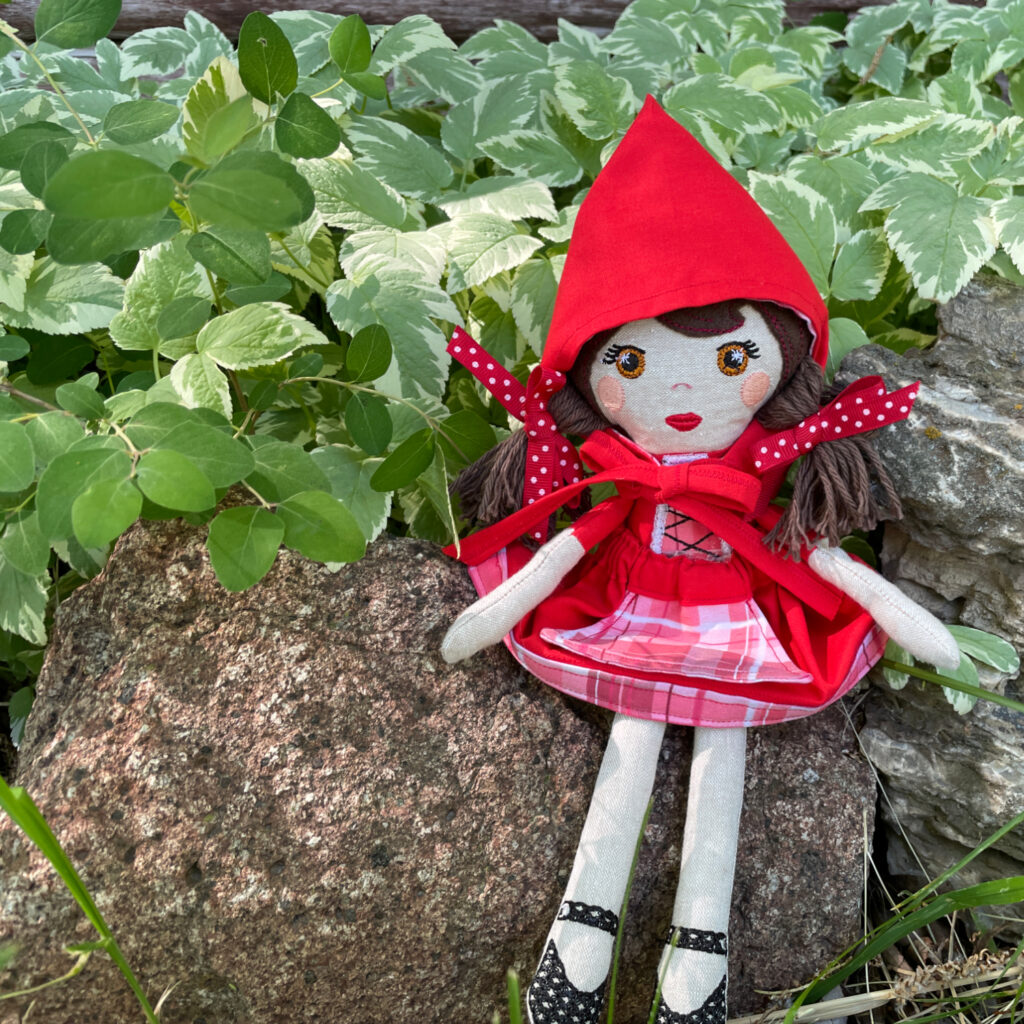 My Little Red doll sitting on the rocky border of a garden. 