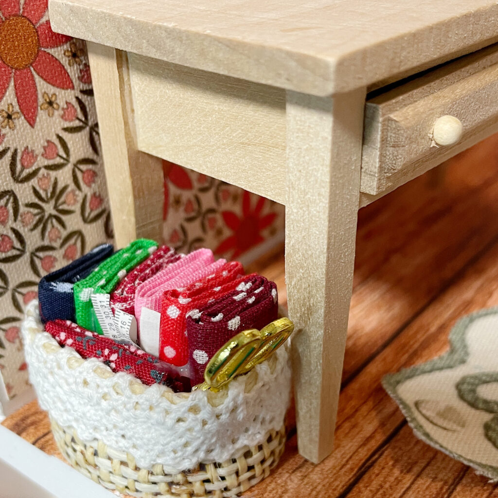 A miniature basket of fabric fat quarters and scissors. 