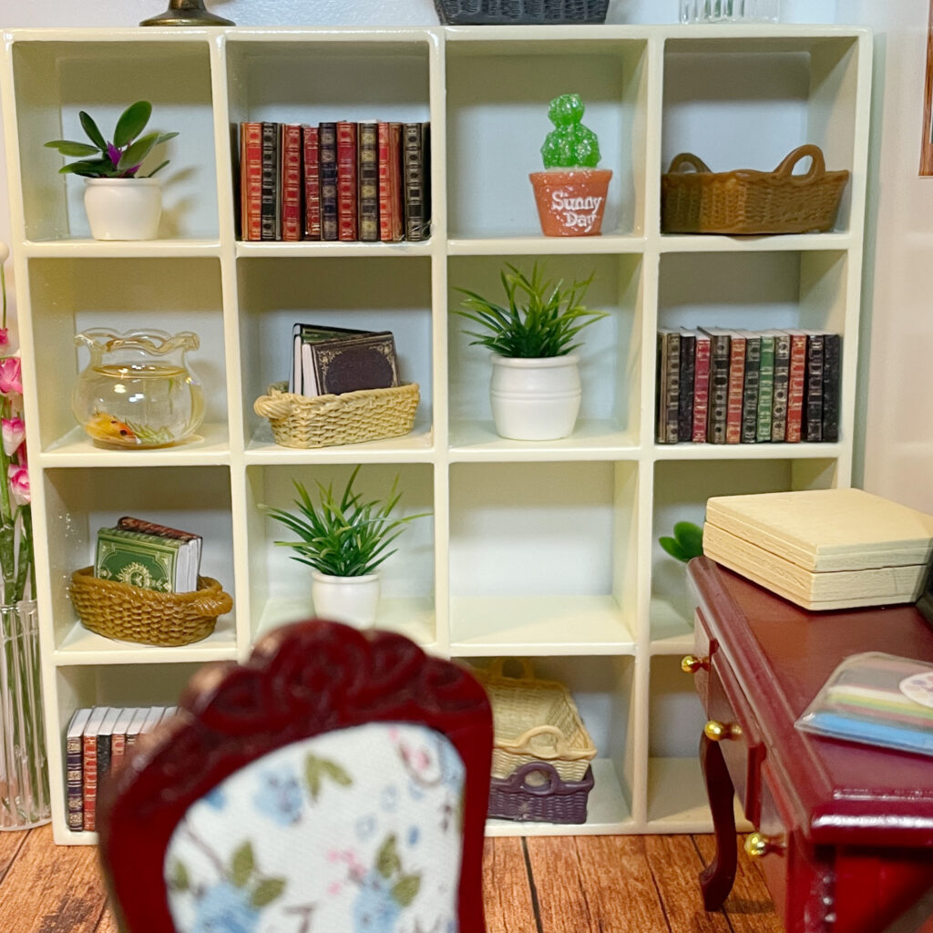 A bookshelf with miniature books and other decorative items.