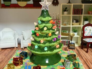 A miniature ceramic Christmas tree surrounded by presents.