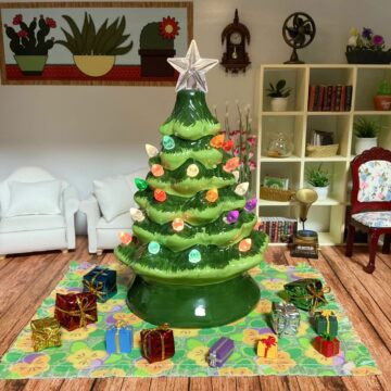 A miniature ceramic Christmas tree surrounded by presents.