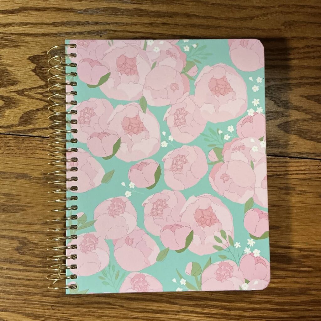 My planner from Sprouted. It has painted pink flowers with a turquoise background. 