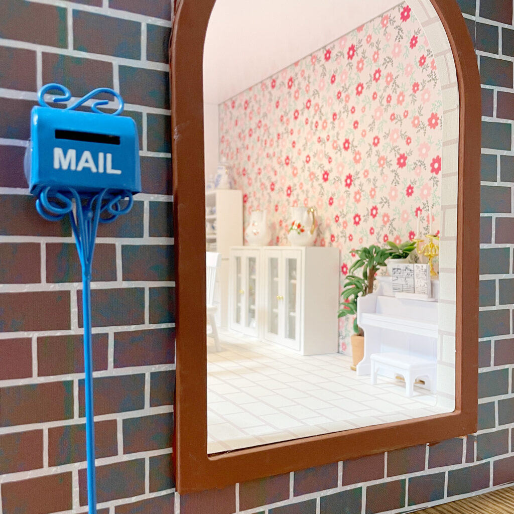 There's a tiny mailbox outside the front door of the dollhouse! 